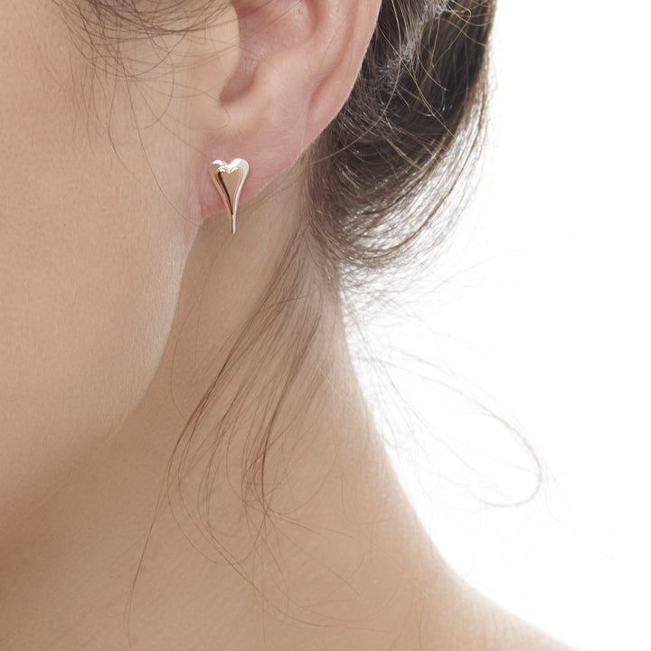 Model wearing 925 sterling silver elongated heart studs with middle heart of rose gold (E50901)