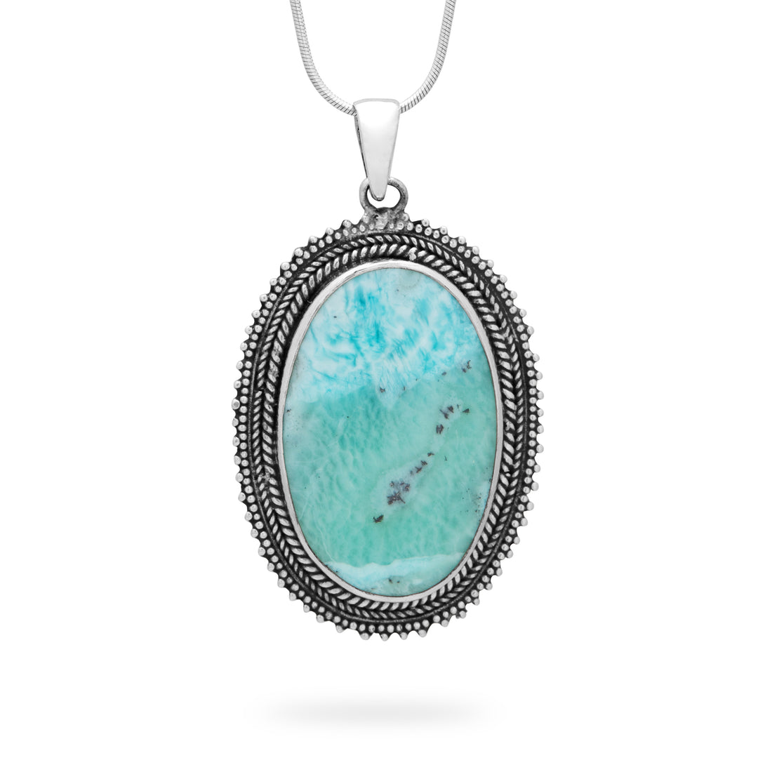 Turquoise stone pendant on a silver chain against a white background