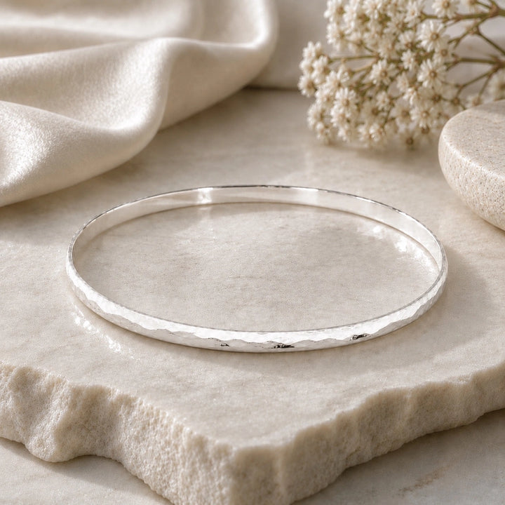  A feminine, dainty bangle with a flat, hammered plemished finish in high quality sterling silver 