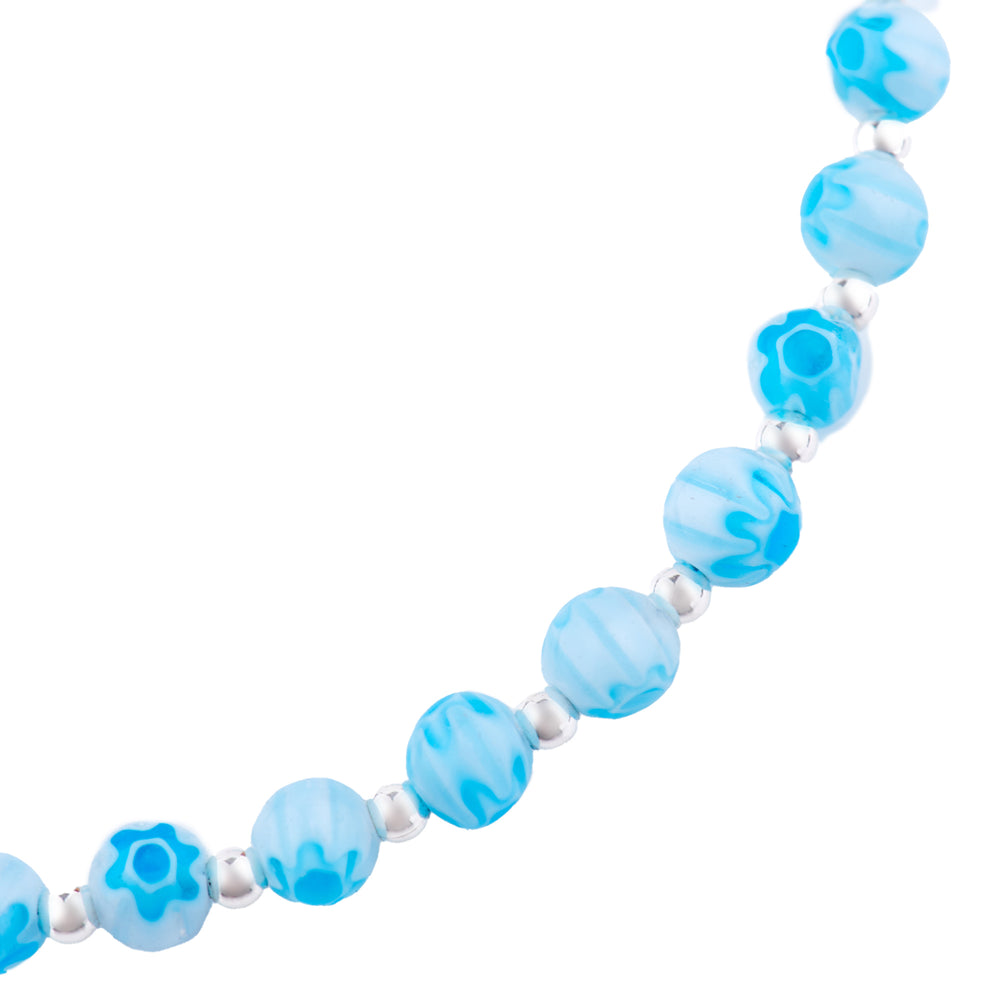 A blue Venetian glass bead anklet with a silver clasp and flower print close up