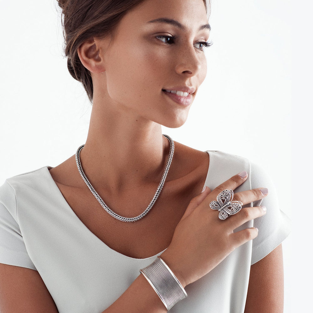 A woman wearing a silver Balinese chain necklace with a clasp, featuring a high polish and oxidised finish.