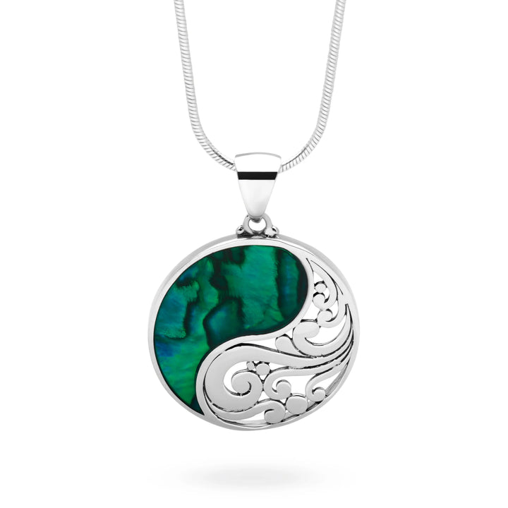 Silver necklace with a green and black circular pendant on a white background