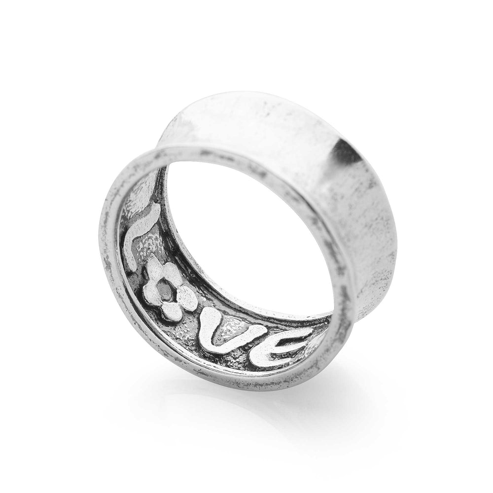 A sterling silver ring with a concave outside and an oxidised interior where the message of LOVE is found, featuring a shabby chic design.