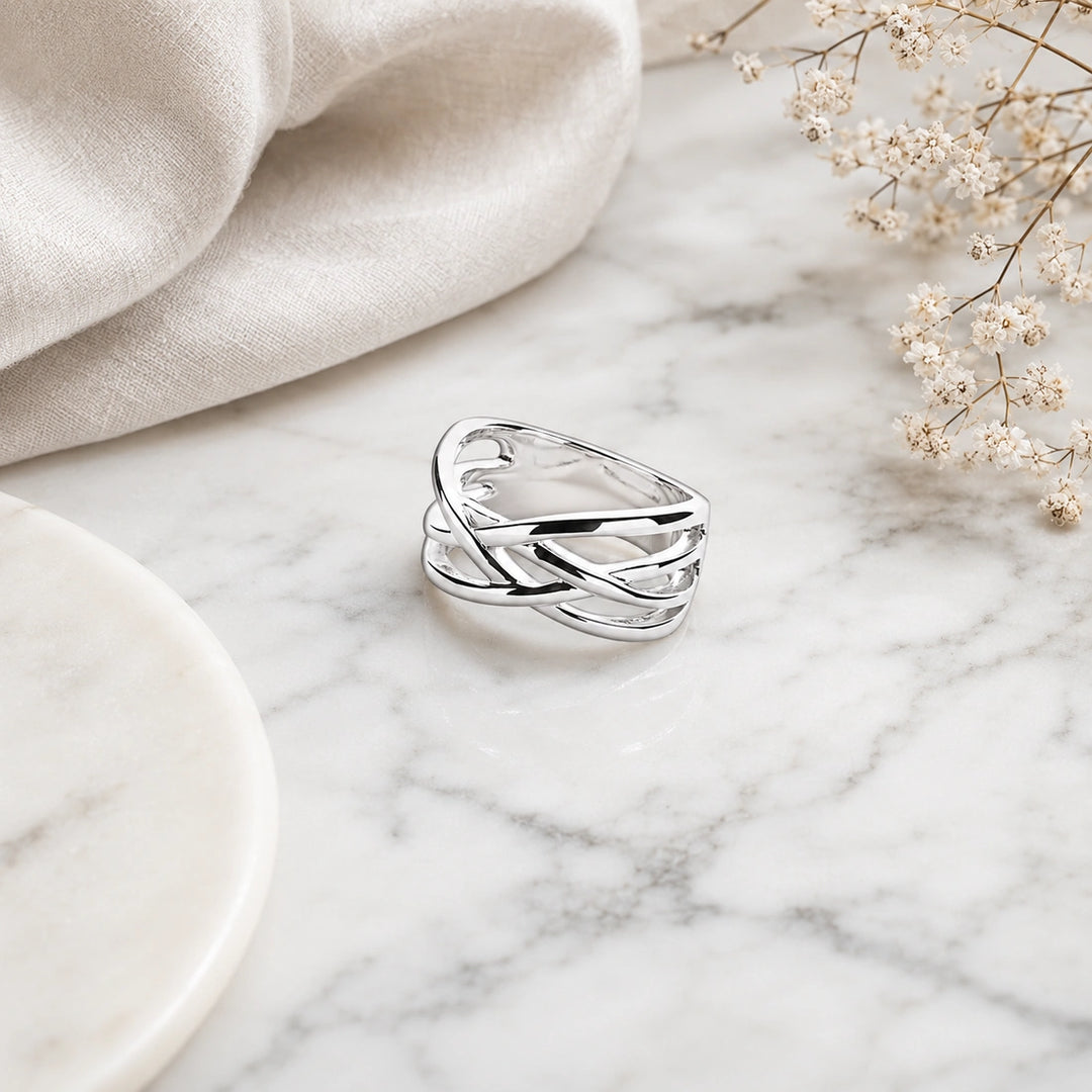 A wide sterling silver crossover ring with smooth, intertwined multi-strand lattice bands.