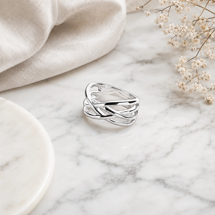 A wide sterling silver crossover ring with smooth, intertwined multi-strand lattice bands.