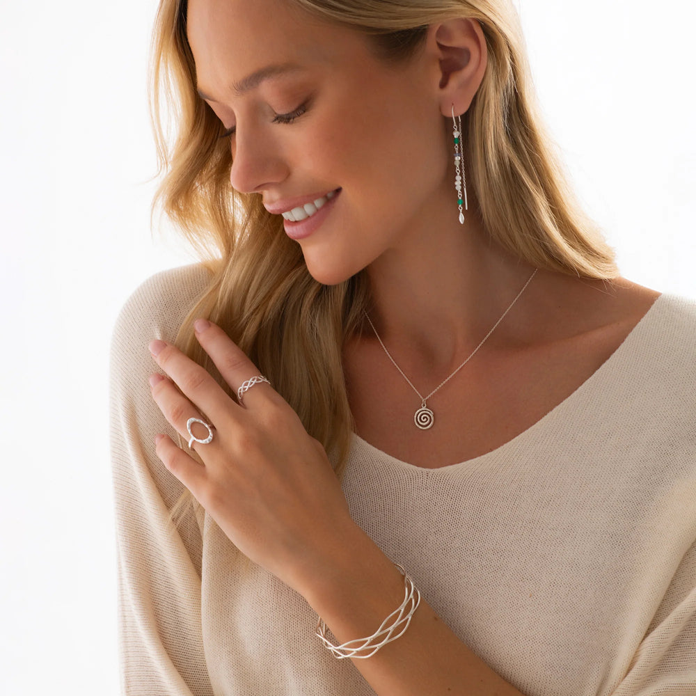 A silver infinity-style ring with a boho vibe, displayed on a woman model.