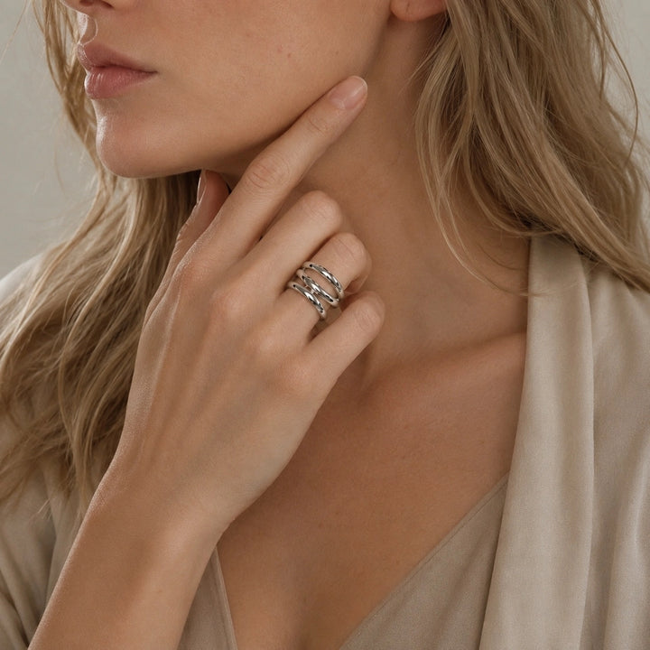 A stylish 925 sterling silver band with a twisted design which wraps around the ring, shown on model.