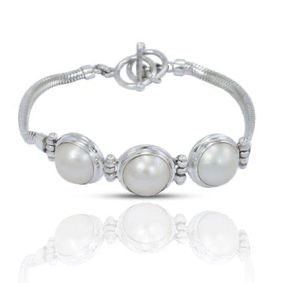 Silver bracelet with three pearl beads on a white background
