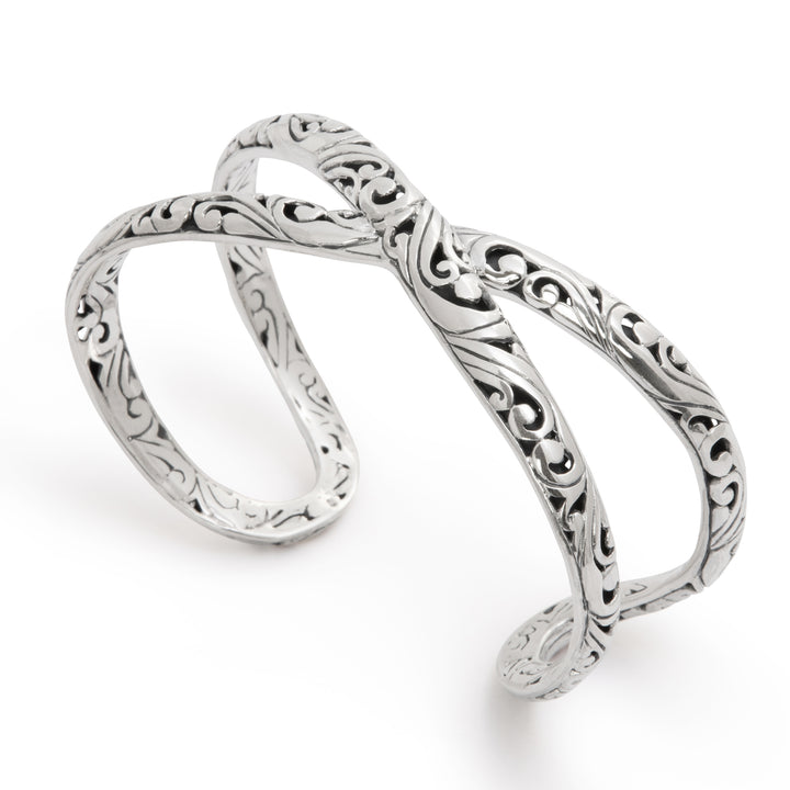 Silver infinity ring with intricate designs on a white background