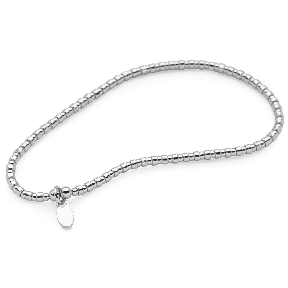 A bracelet made of mini silver pebble beads with a high polish finish, featuring a high polish finish and a small circular charm at the end.