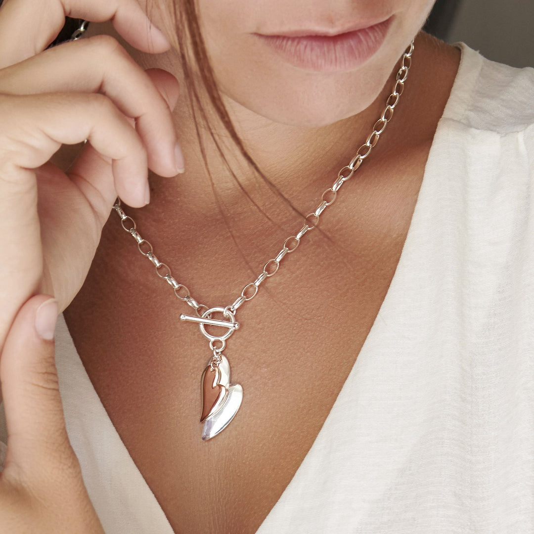 Model wearing 925 sterling silver heart with a second rose gold plated heart necklace (CHN10991)