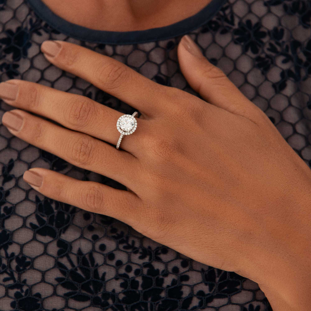 A silver ring with a central clear cubic zirconia stone in a pavé setting, surrounded by smaller sparkling cubic zirconia stones on the band.