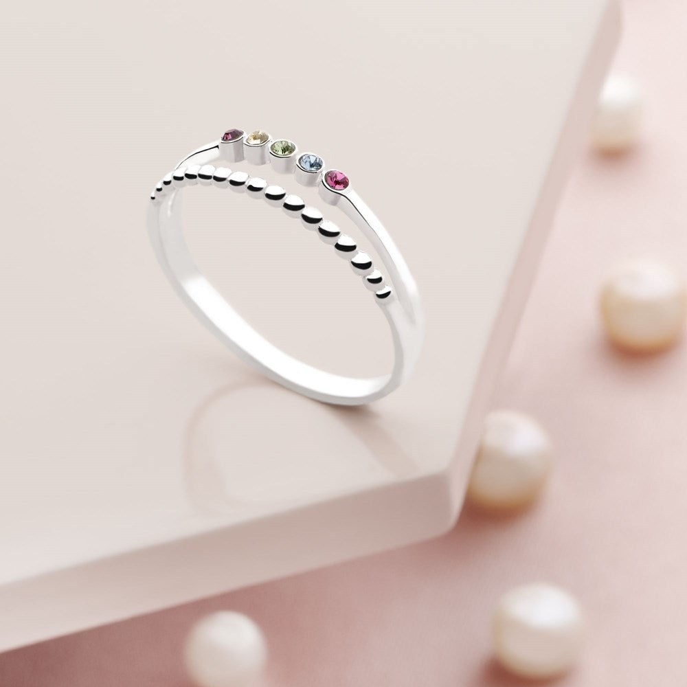 A silver ring with multiple multicolored cubic zirconia stones set across the top, with a high polish finish.